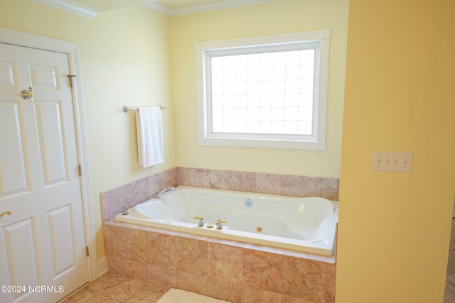 bathroom featuring ornamental molding, tiled tub, and tile patterned flooring