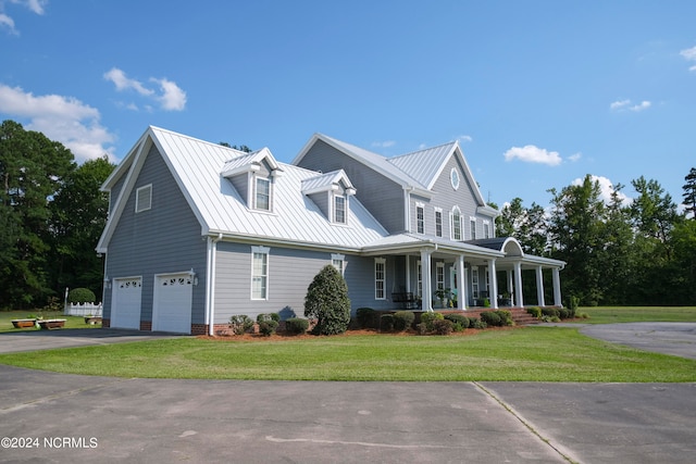 view of front of house featuring a porch, a front lawn, and a garage