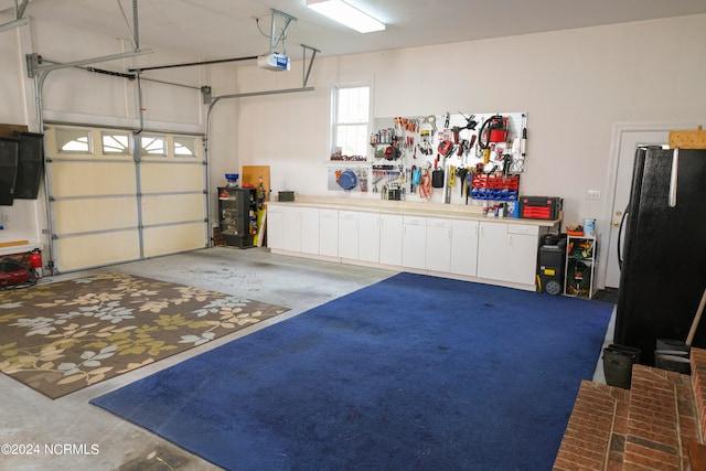 garage featuring a garage door opener and black fridge