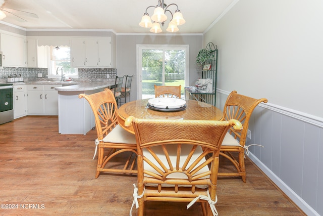 dining area featuring crown molding, light hardwood / wood-style flooring, and ceiling fan with notable chandelier