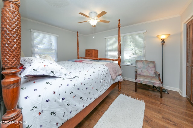 bedroom with crown molding, dark hardwood / wood-style floors, a closet, and ceiling fan