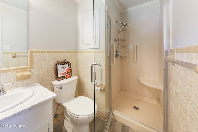 bathroom featuring vanity, toilet, tile walls, and a shower with door