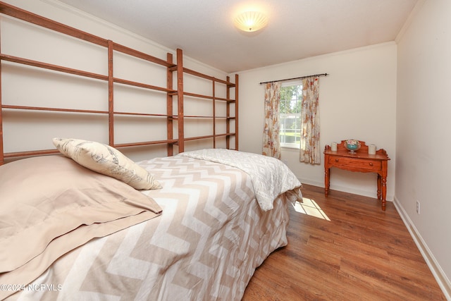 bedroom with crown molding, a textured ceiling, and hardwood / wood-style floors