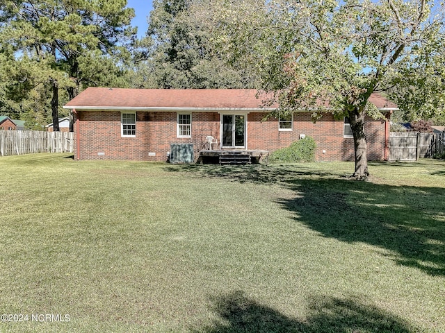 rear view of property featuring a lawn