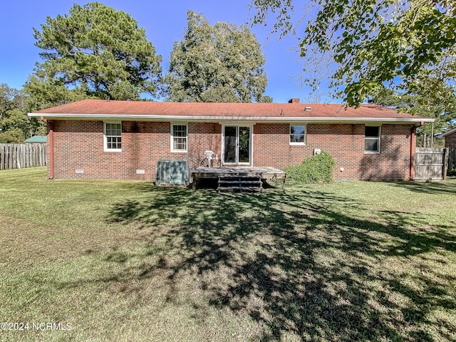 back of property with a yard and a wooden deck