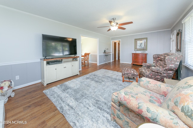 living room with ornamental molding, dark hardwood / wood-style floors, and ceiling fan