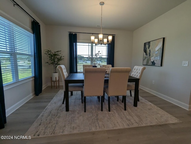 dining room featuring a healthy amount of sunlight, a chandelier, and hardwood / wood-style floors