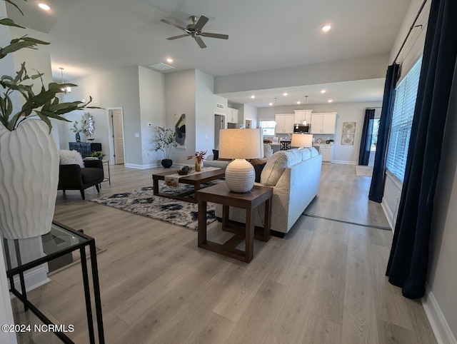 living room featuring ceiling fan and light hardwood / wood-style flooring