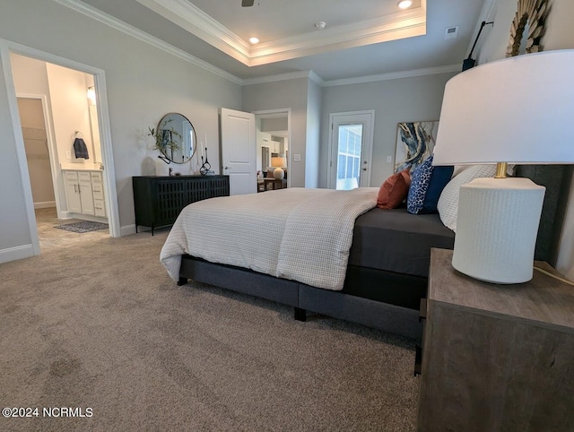 bedroom with connected bathroom, carpet, a tray ceiling, and ornamental molding