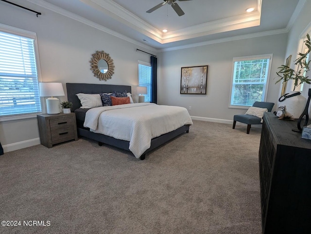 bedroom featuring ceiling fan, carpet, a tray ceiling, and ornamental molding