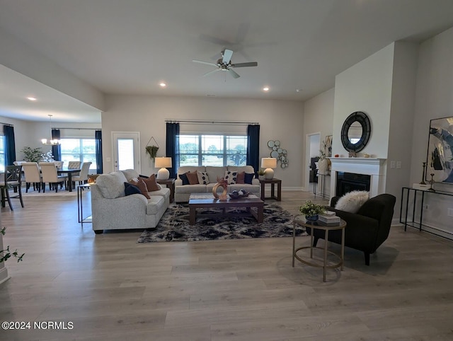 living room with ceiling fan, plenty of natural light, and light wood-type flooring