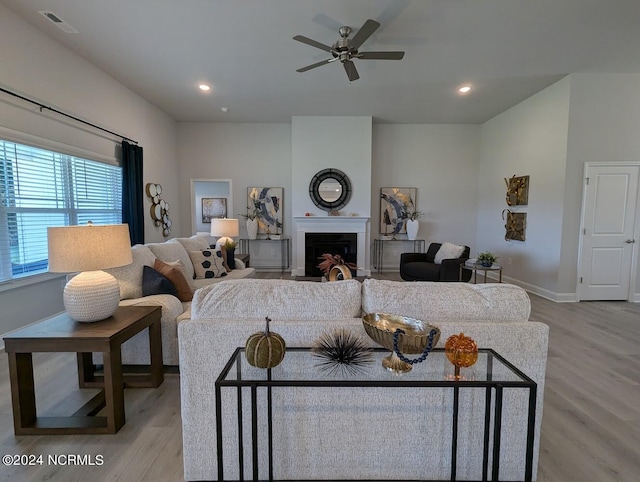 living room with light hardwood / wood-style flooring and ceiling fan