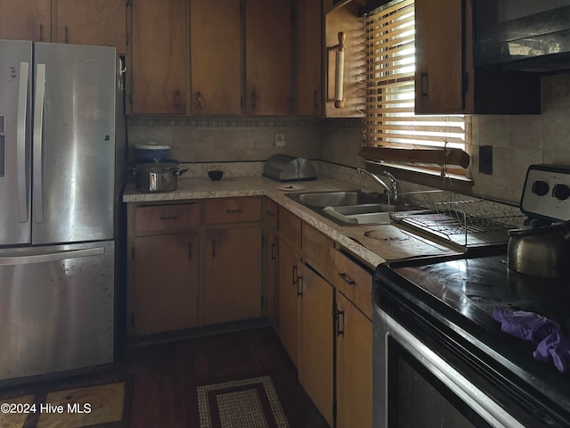 kitchen with tasteful backsplash, dark hardwood / wood-style flooring, sink, and stainless steel appliances