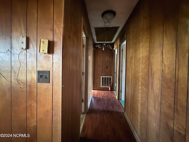 hall featuring wooden walls and dark hardwood / wood-style flooring