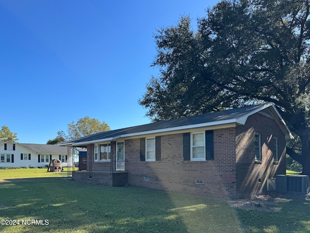 view of front of property with a front yard and central AC