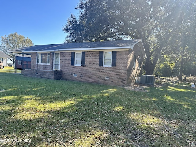 view of front of house featuring a front yard and central AC