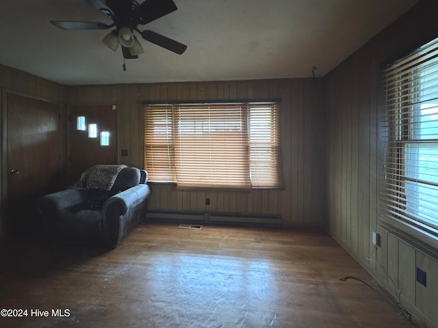 unfurnished room with plenty of natural light, ceiling fan, and wooden walls