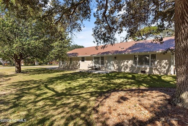 back of property with a yard and a patio area