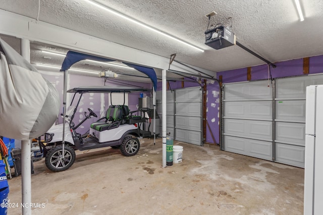 garage with a garage door opener and white refrigerator