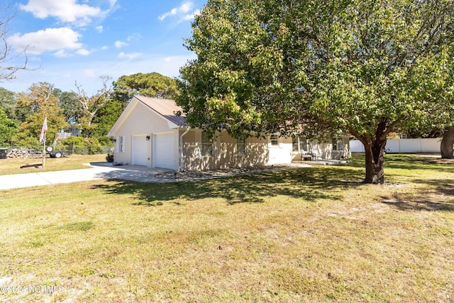 view of side of home featuring a garage and a lawn