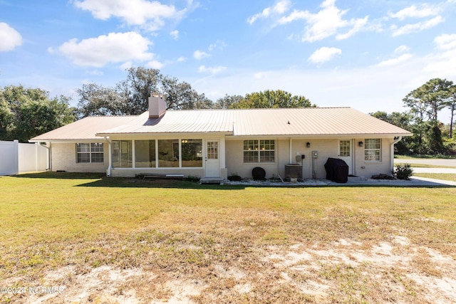 view of front of home featuring a sunroom and a front lawn