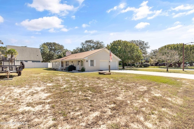 view of side of property featuring a garage and a lawn