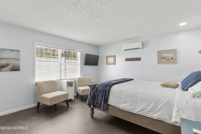 bedroom featuring a wall mounted AC and a textured ceiling