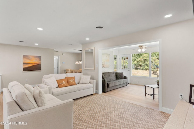 living room with ceiling fan and light wood-type flooring