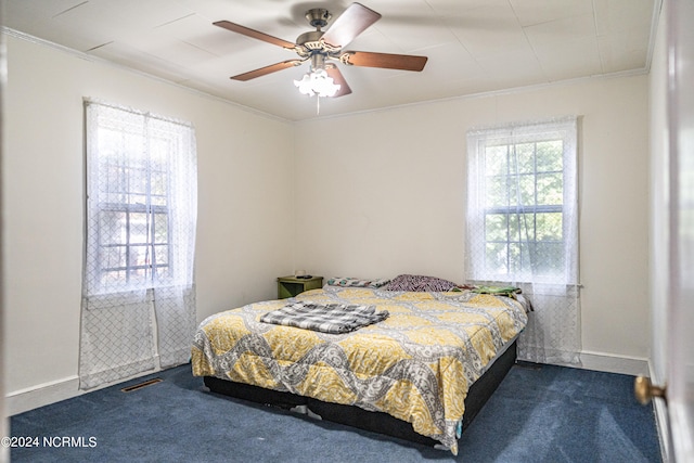 carpeted bedroom with ceiling fan and crown molding