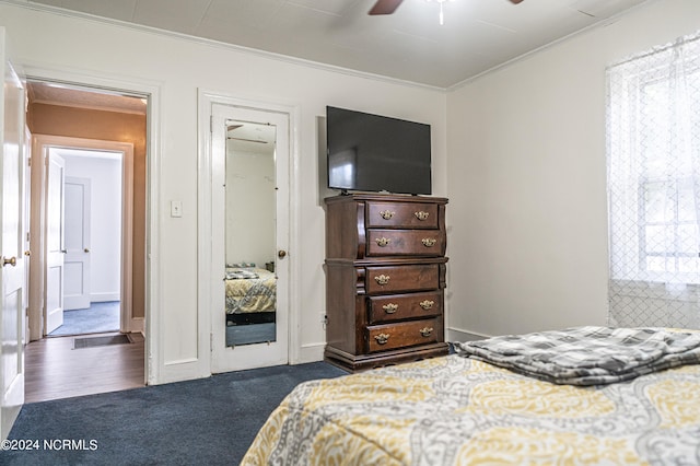 bedroom featuring crown molding, dark hardwood / wood-style floors, and ceiling fan