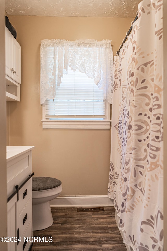 bathroom featuring vanity, wood-type flooring, toilet, and walk in shower