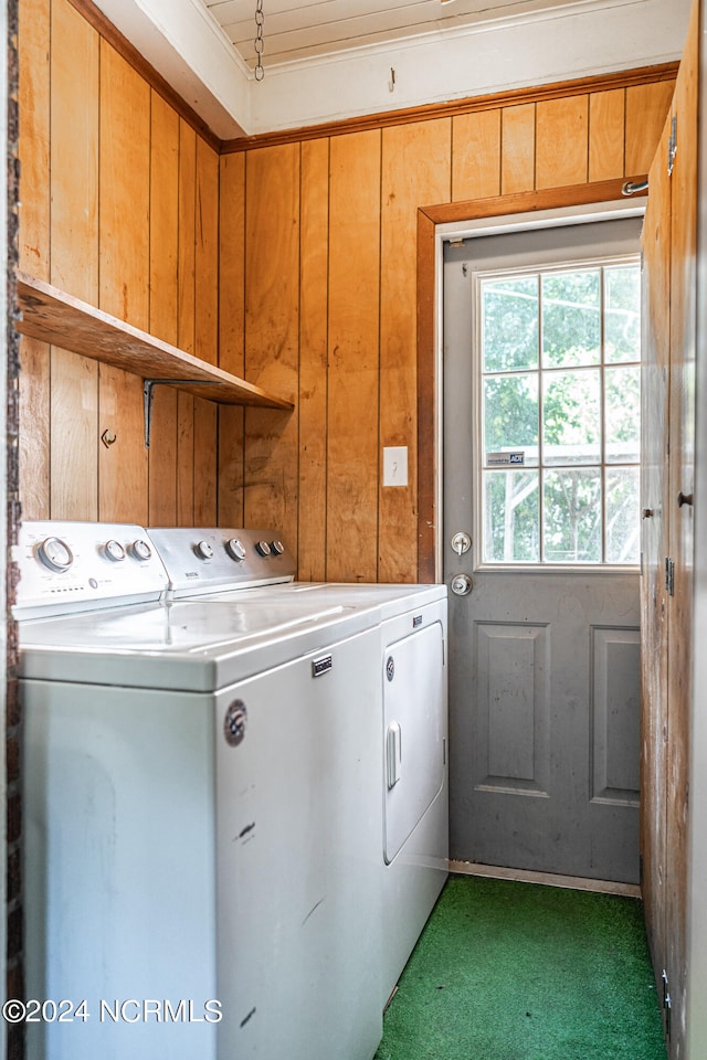 laundry area featuring carpet, washing machine and dryer, and wood walls