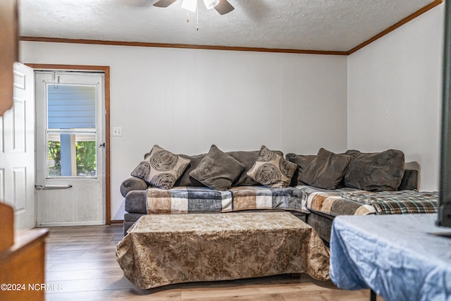 living room with ceiling fan, crown molding, a textured ceiling, and hardwood / wood-style floors