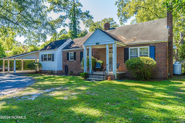 view of front of home with a front lawn and a carport