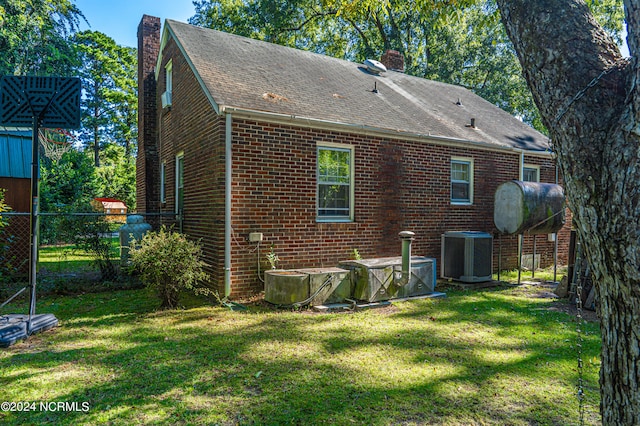 back of house with a yard and central AC unit