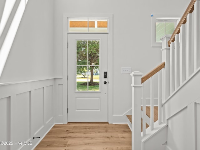 103 Cumberland St, Newport, NC 28570 - entryway with light wood-type flooring, stairs, healthy amount of natural light, a decorative wall, and wainscoting
