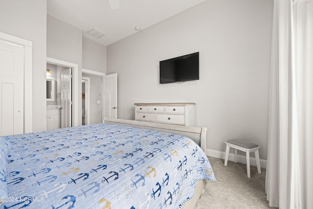 bedroom with ensuite bathroom, ceiling fan, and light colored carpet