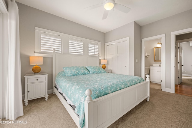 carpeted bedroom featuring connected bathroom, ceiling fan, and a closet