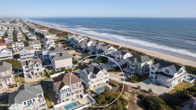 birds eye view of property featuring a water view and a beach view