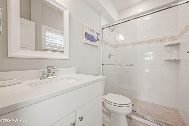 bathroom with vanity, toilet, and a shower with shower door