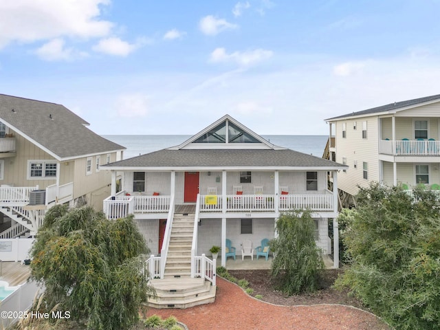 view of front of house featuring central AC unit and a water view