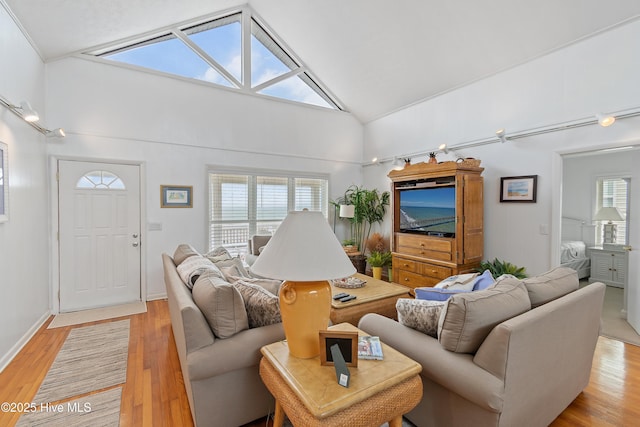 living room with high vaulted ceiling and light wood-type flooring