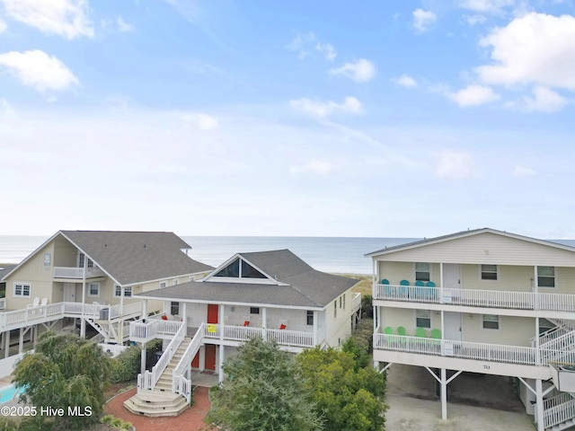 back of house with a carport and a water view