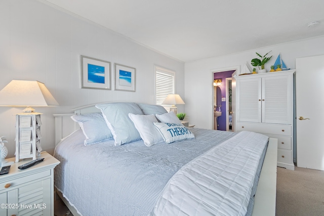 carpeted bedroom featuring ensuite bath