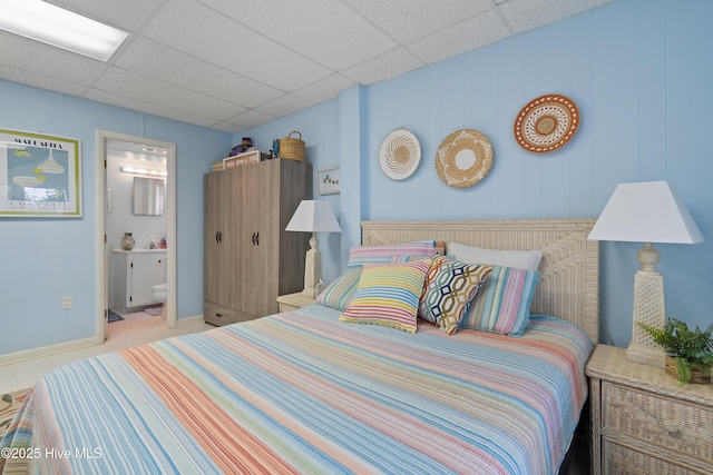 bedroom with a paneled ceiling and connected bathroom