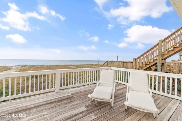 wooden deck with a beach view and a water view