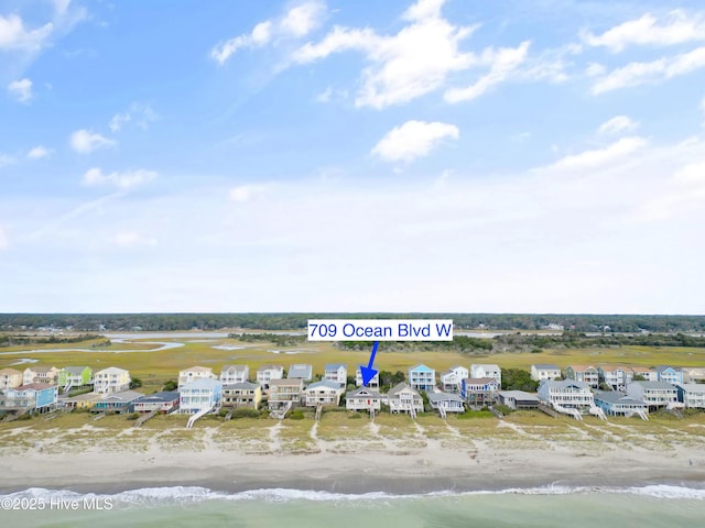 birds eye view of property featuring a water view and a beach view