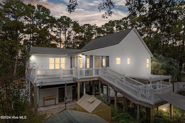 rear view of property with stairs, roof with shingles, and a wooden deck