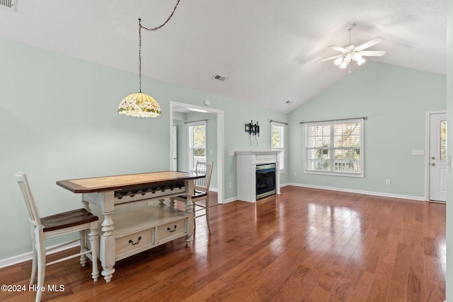 living room with dark wood-style flooring, visible vents, a fireplace, and a healthy amount of sunlight