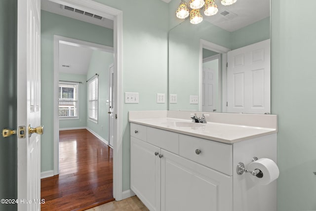 bathroom with visible vents, wood finished floors, vanity, and baseboards